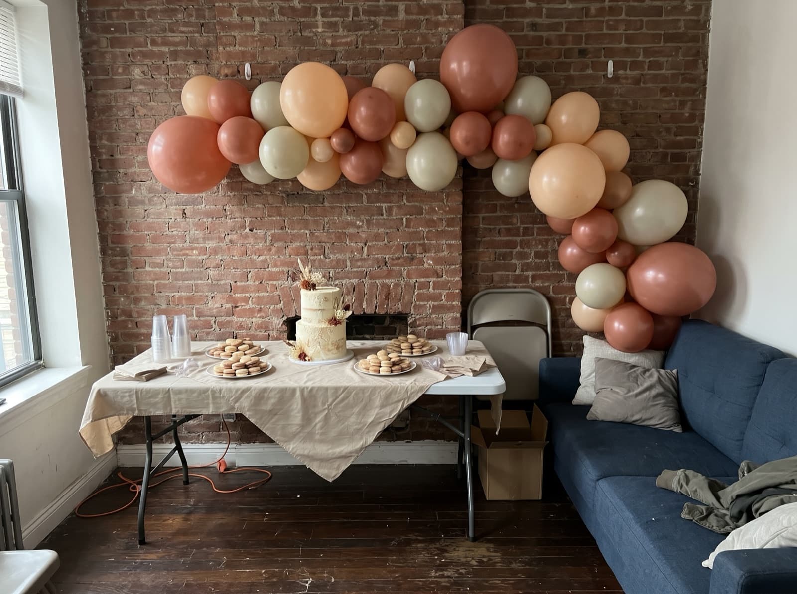Organic balloon arch in terracotta, peach and cream over a dessert table