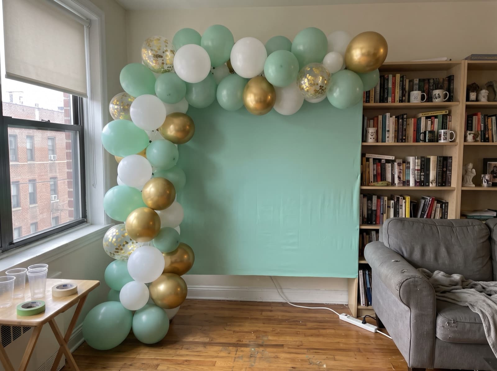 Square mint backdrop with a balloon garland up one side