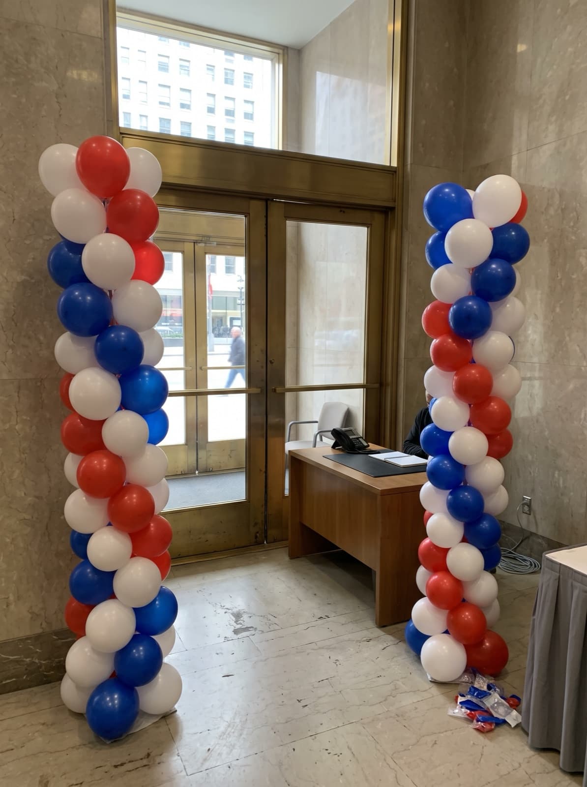 Red, white and blue spiral balloon columns in an office lobby