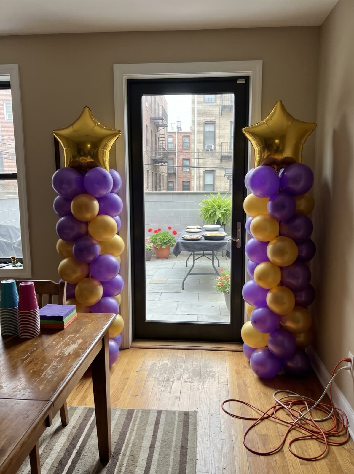 Purple and gold balloon columns with star toppers for a graduation