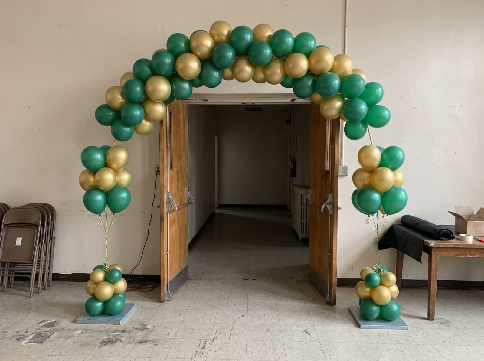 Emerald and gold balloon columns joined by an arch