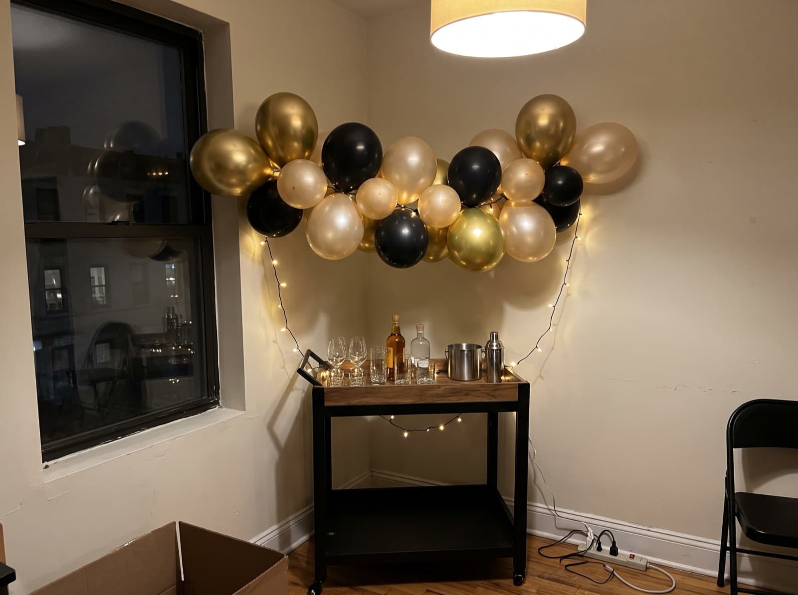 Chrome gold and black balloon garland over a bar cart