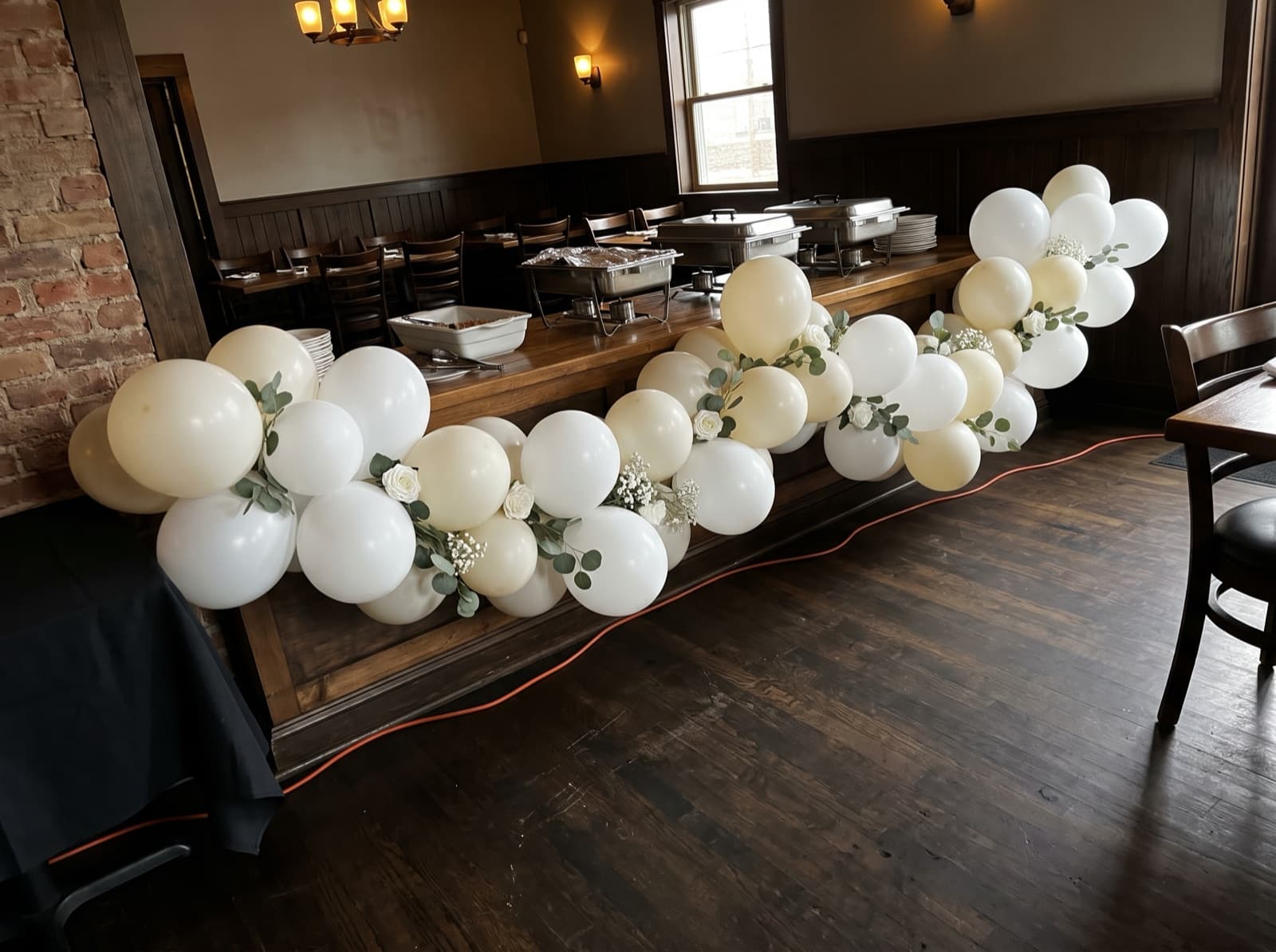 White balloon garland with eucalyptus along a buffet