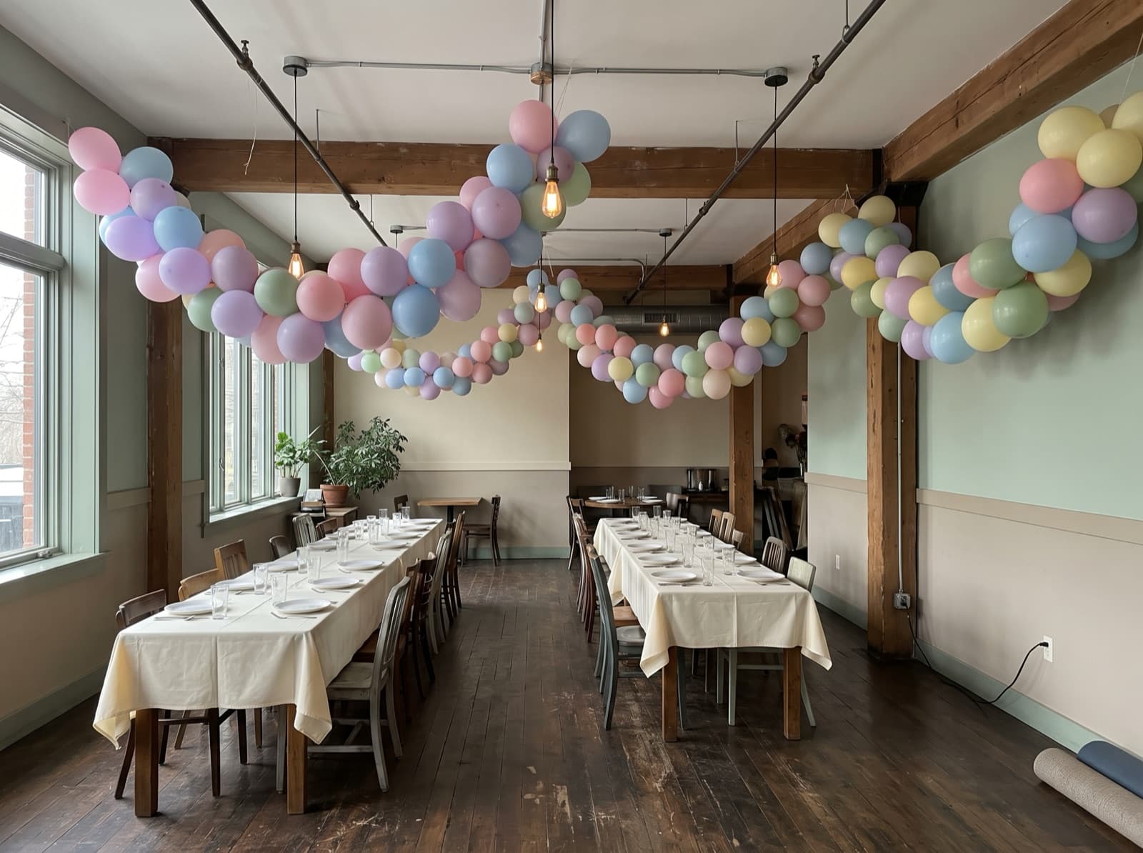Hanging pastel balloon garlands over restaurant dining tables