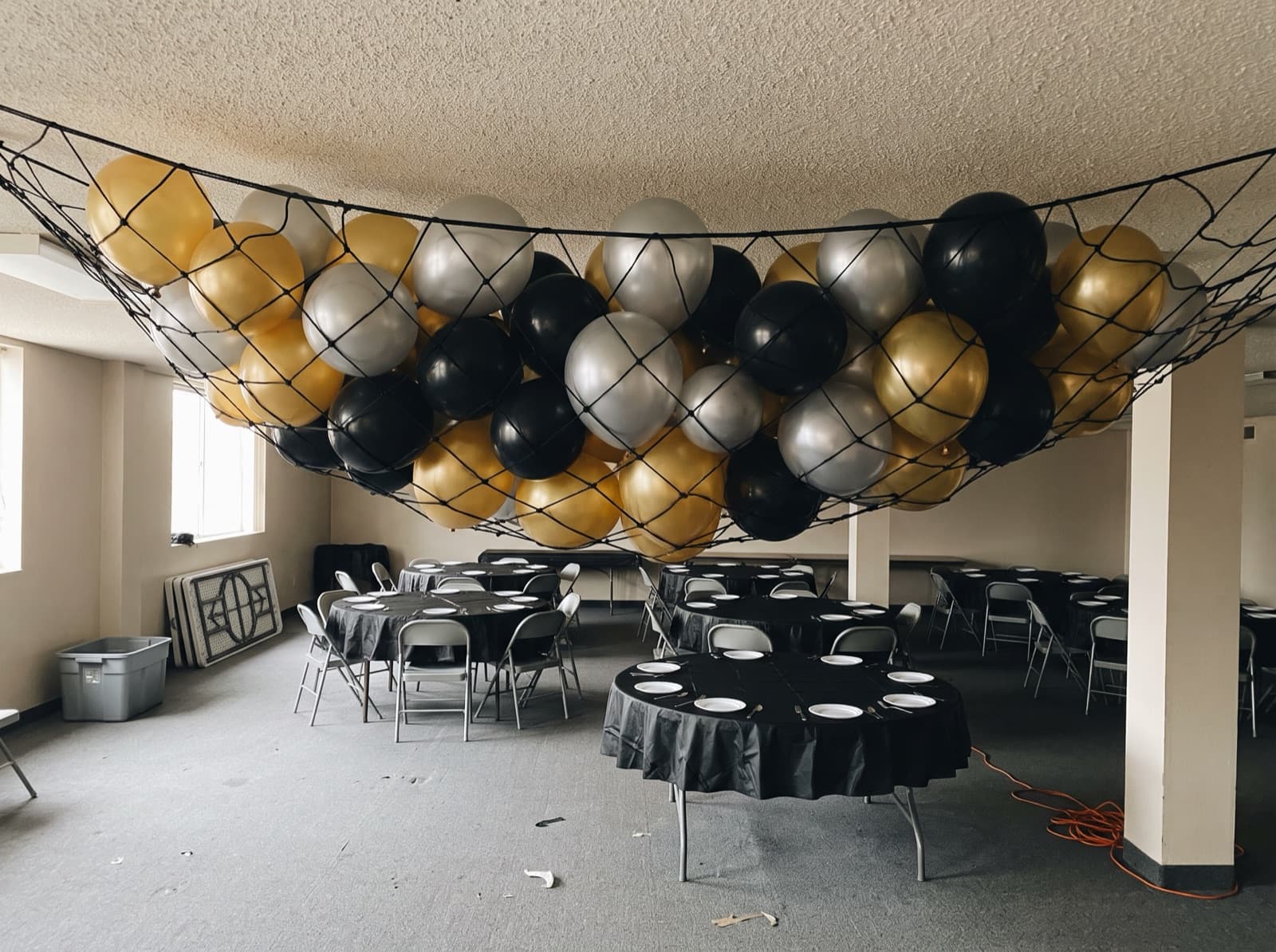 Balloon drop net rigged near the ceiling before a countdown