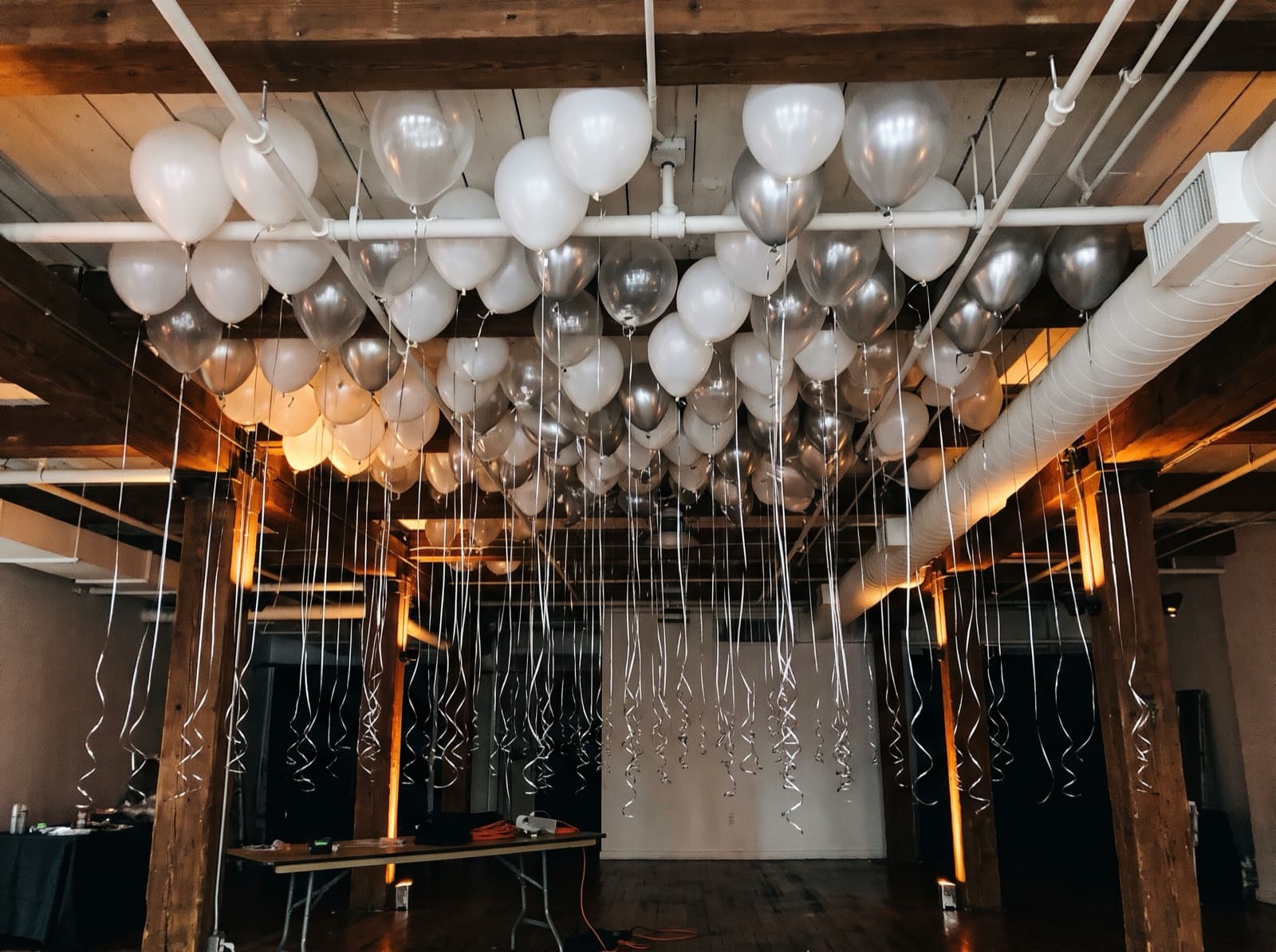 Balloon ceiling of white, clear and silver balloons over the dance floor in a New York loft venue