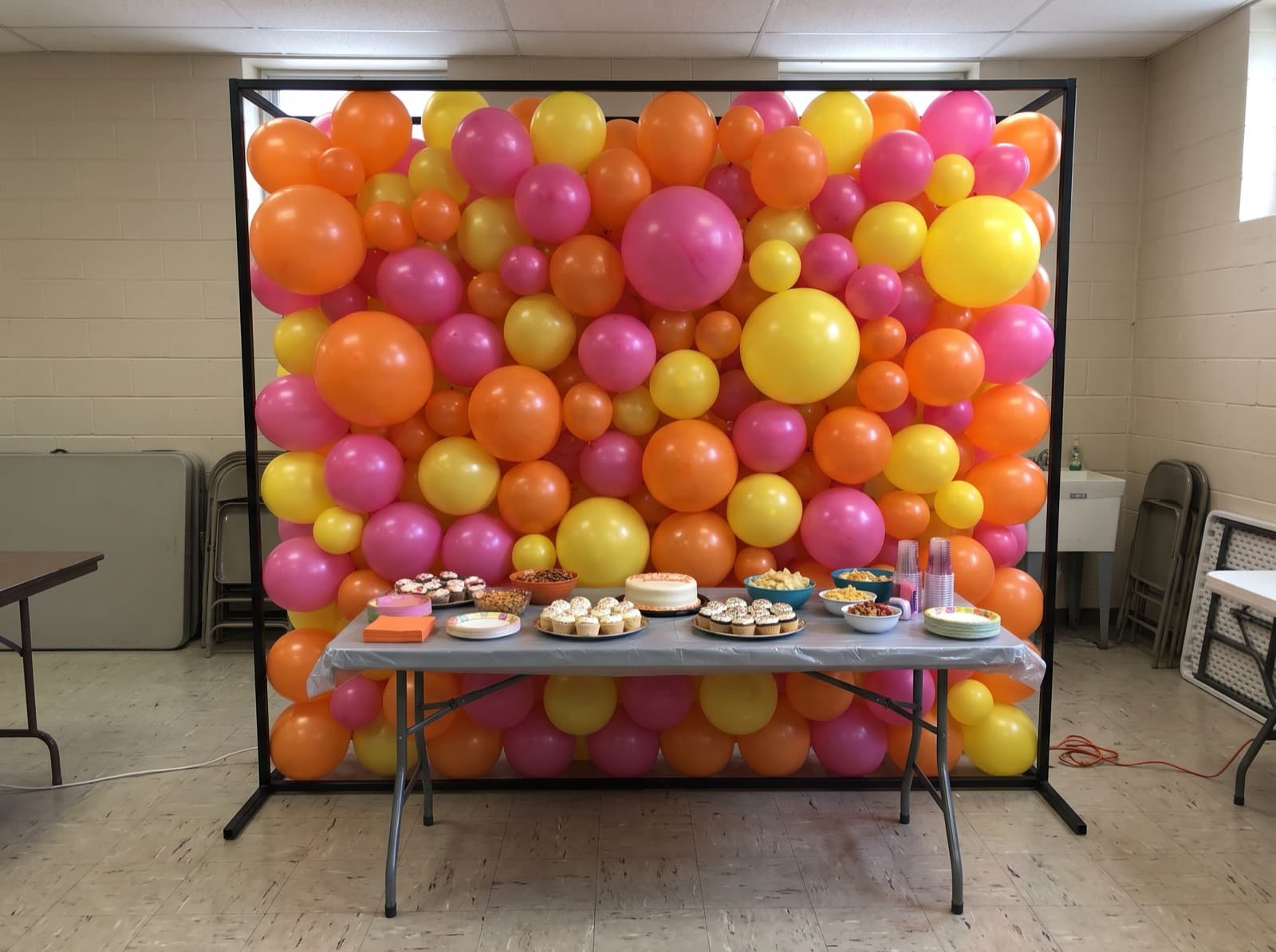 Square framed balloon wall in tangerine, pink and yellow