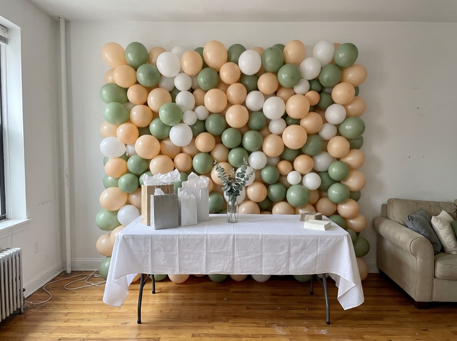 Peach, sage and white balloon wall for a baby shower